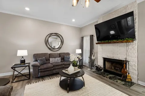 a living room with furniture a flat screen tv and a fireplace