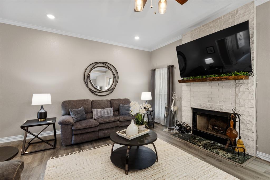 1701 Oakmeadow Drive Decatur, TX 76234 - Photo 13 of 39 a living room with furniture a flat screen tv and a fireplace