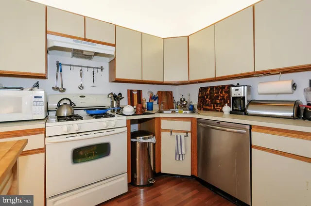 a kitchen with stainless steel appliances granite countertop white cabinets sink and a refrigerator