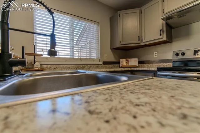 a view of a kitchen with granite countertop a sink and a stove