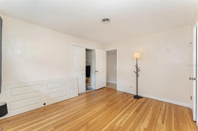 a view of empty room with wooden floor