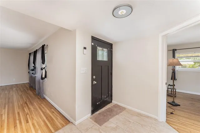 a view of a hallway to rooms and wooden floor