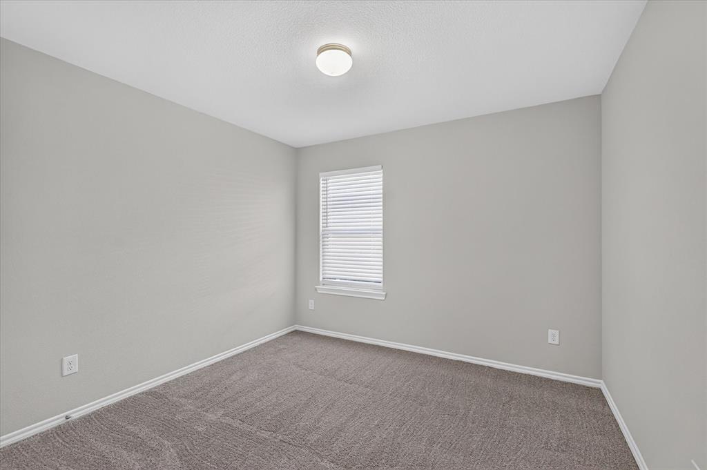 2428 Rosharon Drive Forney, TX 75126 - Photo 18 of 40 Bright secondary bedroom featuring neutral wall finishes, carpet flooring, a generous window with plantation shutters providing natural light, and recessed ceiling lighting