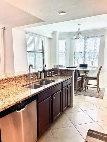 a kitchen with a sink and chairs
