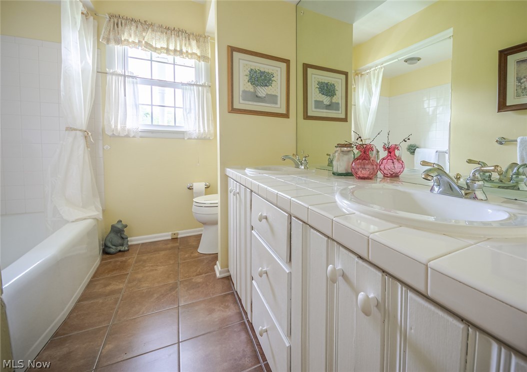 3331 Boyne Road Barberton, OH 44203 - Photo 14 of 22 Full bathroom with tub/shower, dual sink vanity, tile, and plenty of cabinet space.