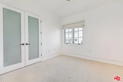 an empty room with windows and closet