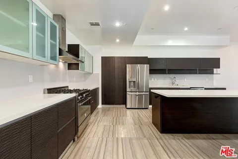 a kitchen with stainless steel appliances kitchen island granite countertop a stove a sink and a microwave