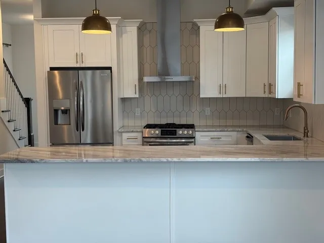 a kitchen with stainless steel appliances granite countertop a refrigerator a sink and a stove