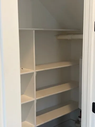 a view of walk in closet with empty racks