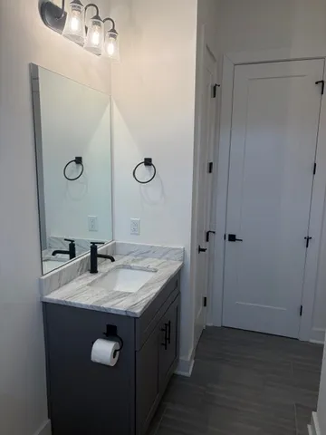 a bathroom with a granite countertop sink and a mirror