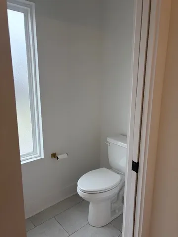 a white toilet sitting next to a window