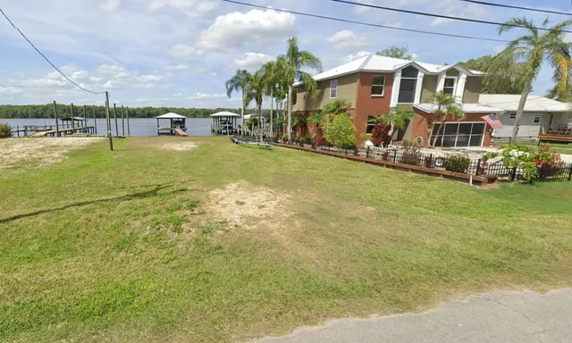 a front view of house with yard and lake view