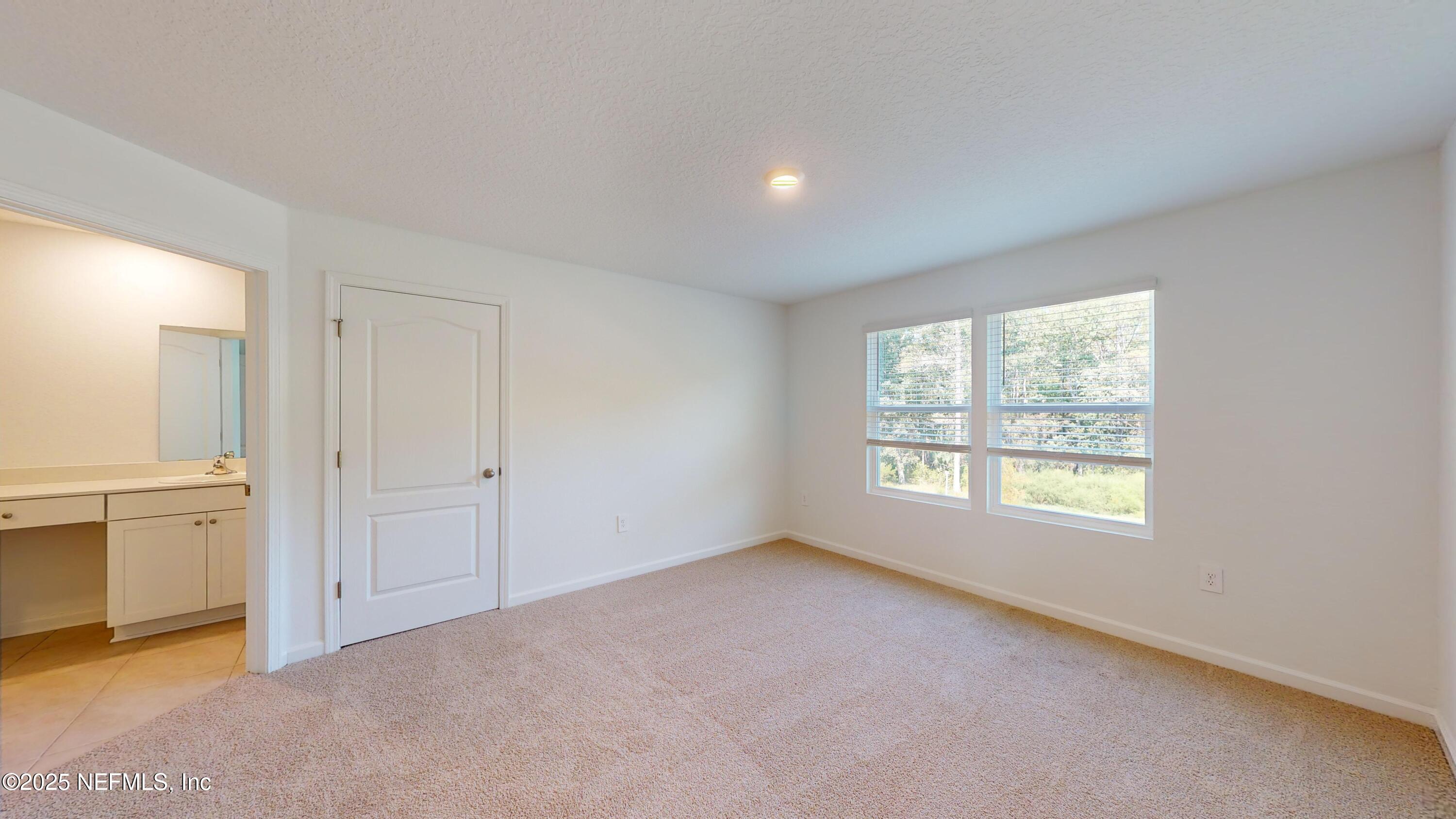 169 Seaport Breeze Road St. Augustine, FL 32095 - Photo 13 of 21 a view of an empty room with a window and a kitchen