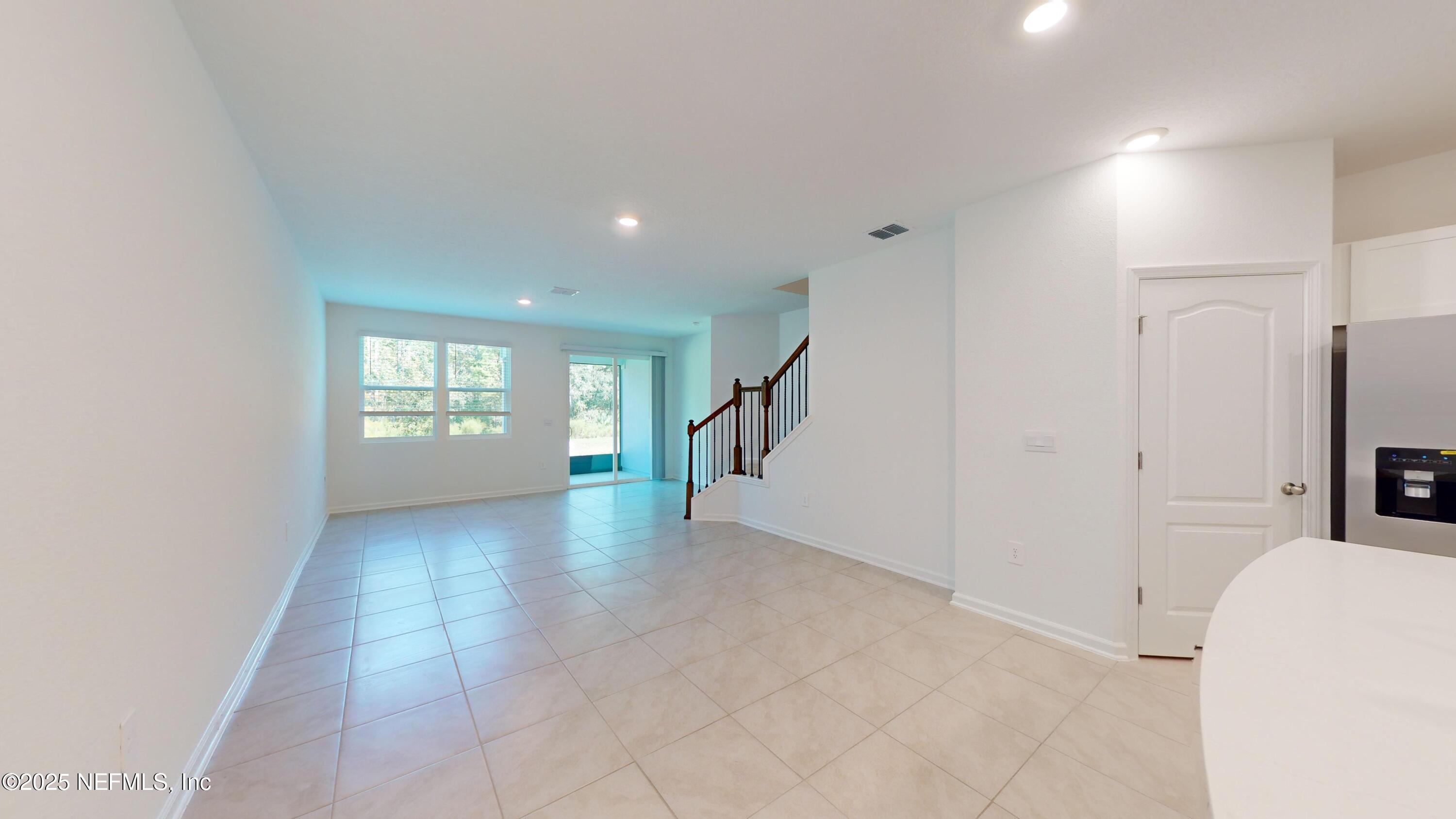 169 Seaport Breeze Road St. Augustine, FL 32095 - Photo 2 of 21 a view of an empty room with a window and a kitchen