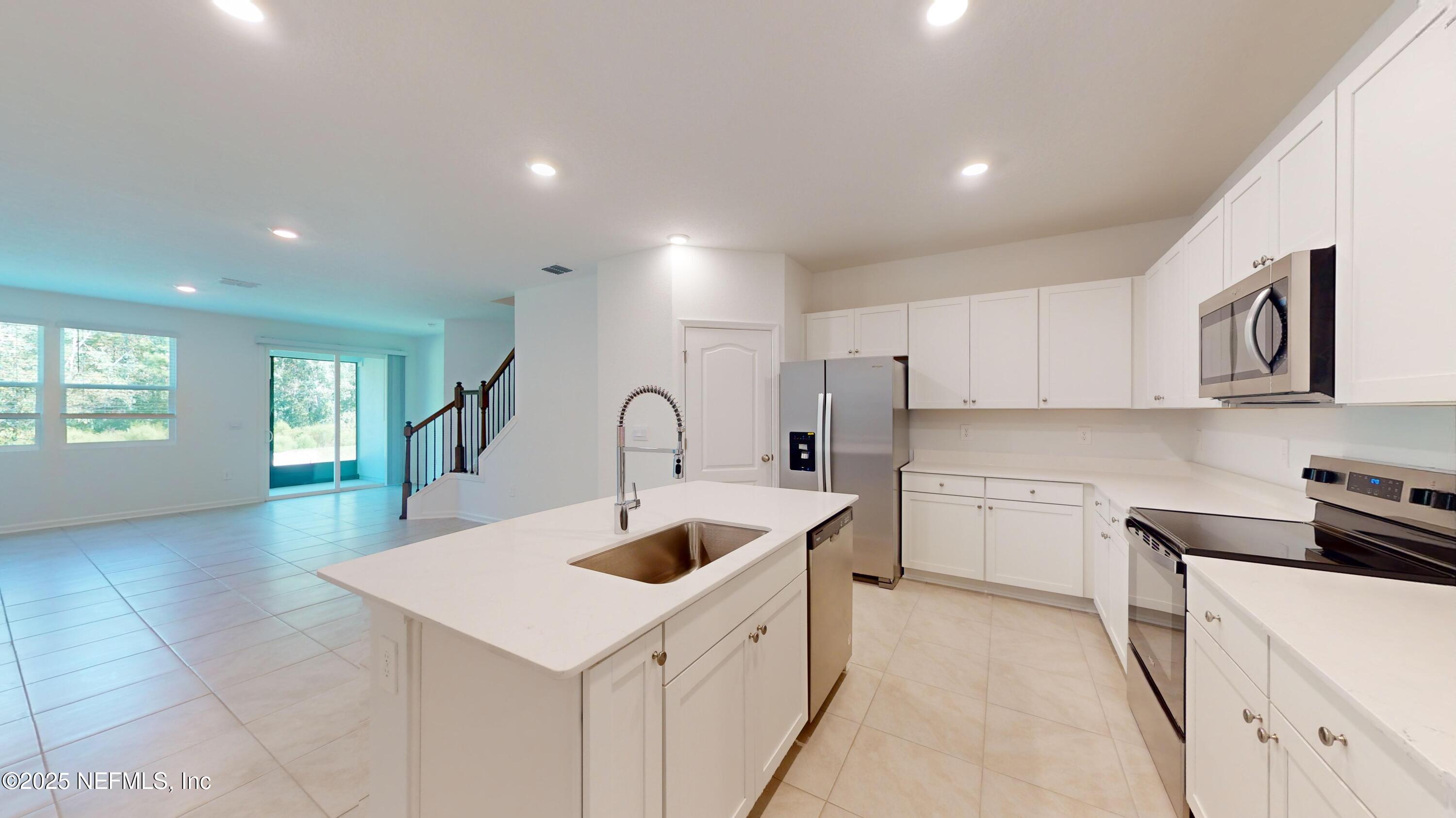 169 Seaport Breeze Road St. Augustine, FL 32095 - Photo 5 of 21 a kitchen that has a sink a stove and cabinets