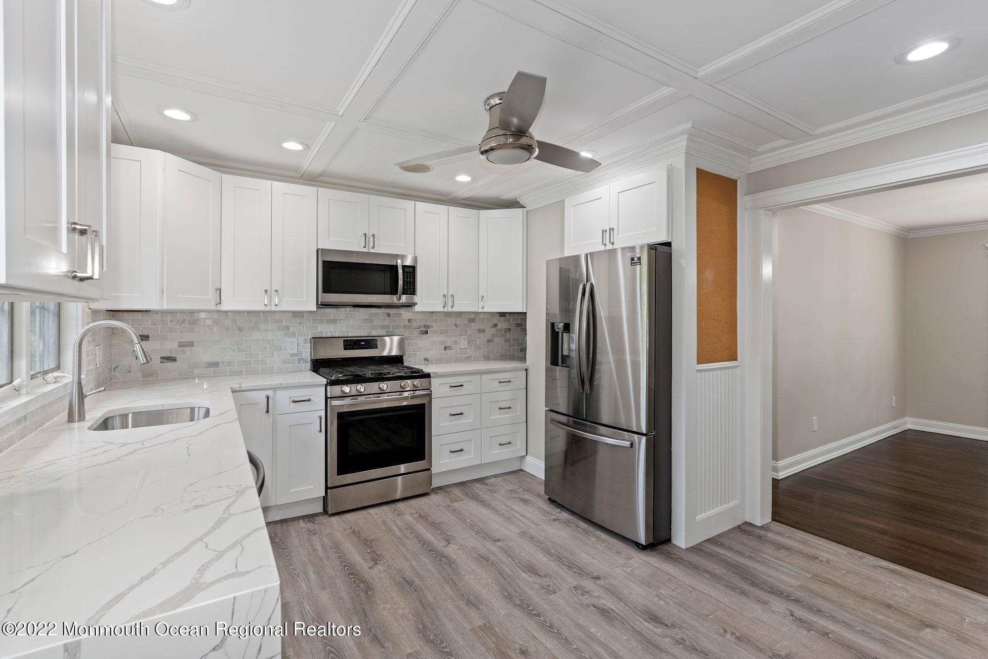738 Holmdel Road Holmdel, NJ 07733 - Photo 14 of 36 a kitchen with a refrigerator stove and wooden cabinets