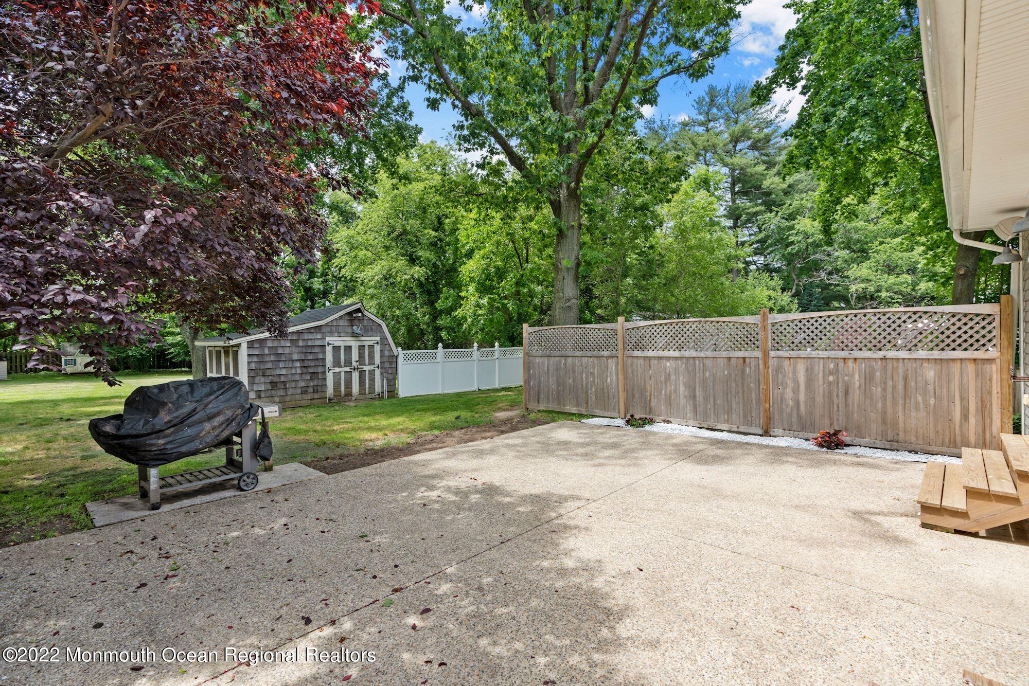 738 Holmdel Road Holmdel, NJ 07733 - Photo 6 of 36 a backyard of a house with barbeque oven and fence