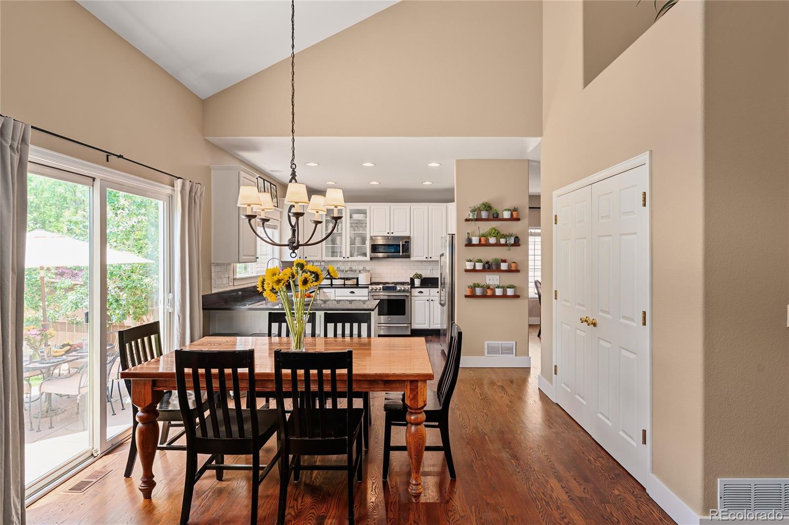 9441 South Hackberry Lane Highlands Ranch, CO 80129 - Photo 22 of 50 a view of a dining room with furniture a chandelier and wooden floor