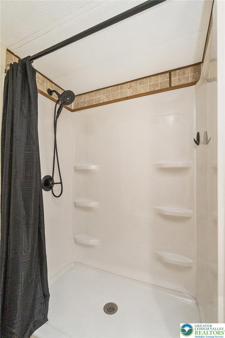 8721 Turkey Ridge Road Breinigsville, PA 18031 - Photo 22 of 30 Tiled border details and dark fixtures accent the clean, functional walk-in shower design.