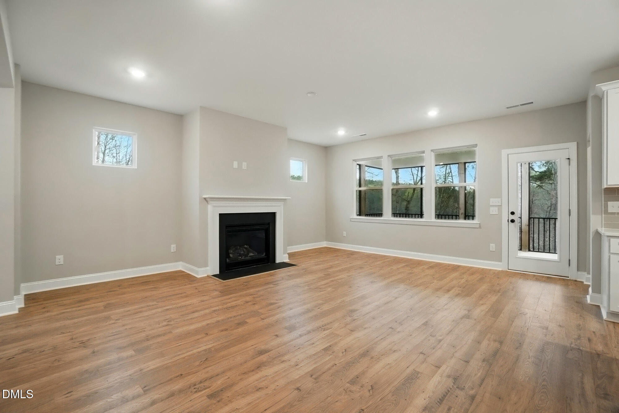 285 Gilliland Road Siler City, NC 27344 - Photo 8 of 45 an empty room with wooden floor fireplace and windows