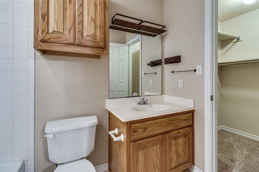 454 East Fulton Street Van Alstyne, TX 75495 - Photo 14 of 25 a bathroom with a granite countertop toilet sink and mirror