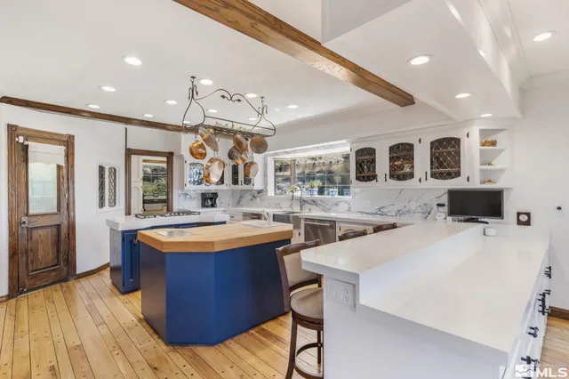 a kitchen with a stove a sink dishwasher and cabinets with wooden floor