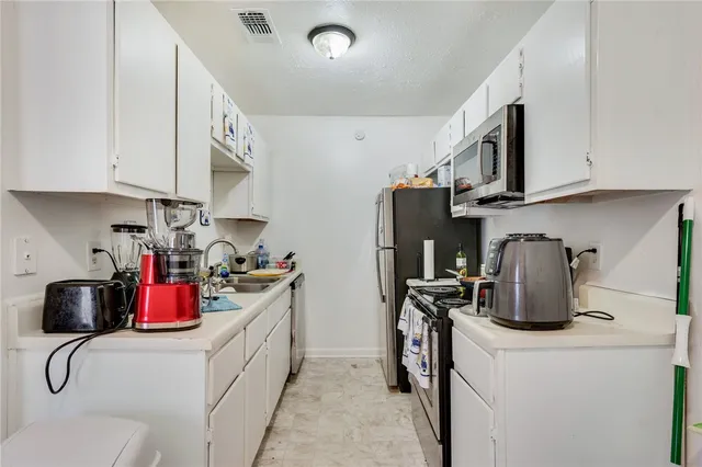 a kitchen with stainless steel appliances granite countertop a sink dishwasher stove top oven and cabinets