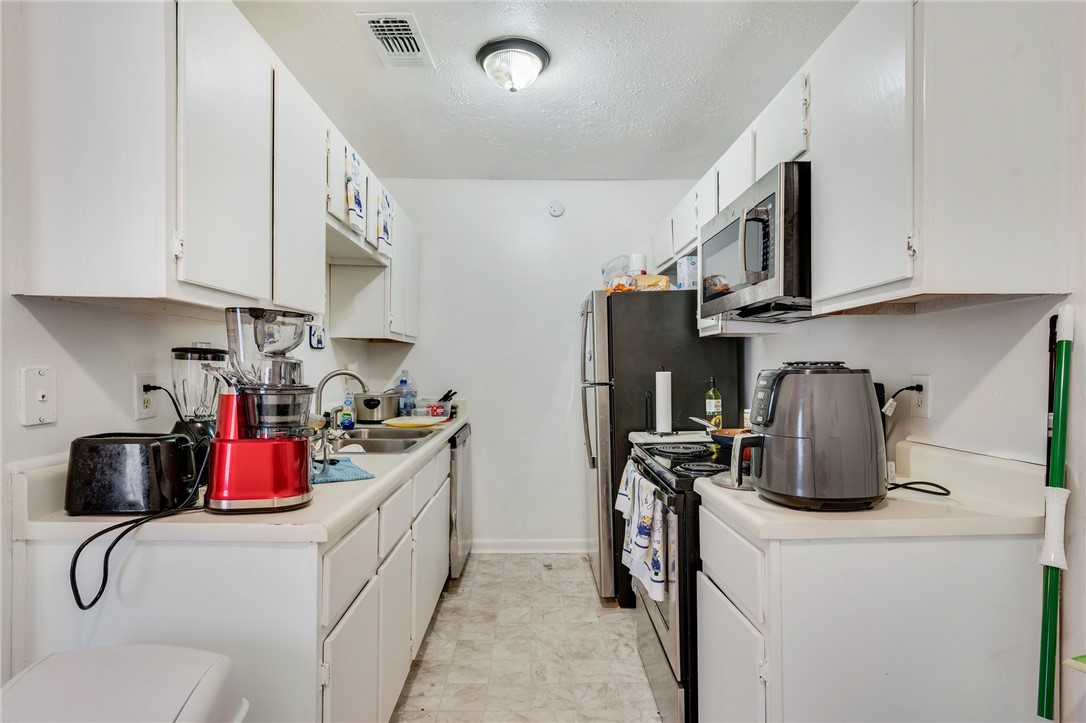 1526 Pine Ridge Drive College Station, TX 77840 - Photo 10 of 17 a kitchen with stainless steel appliances granite countertop a sink dishwasher stove top oven and cabinets