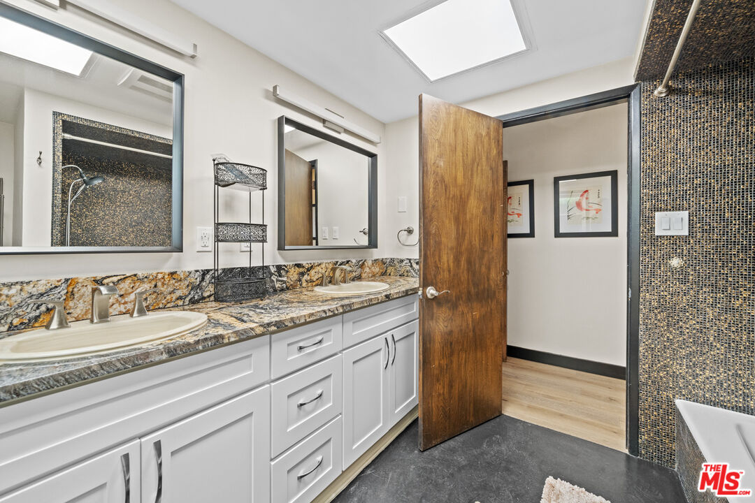 5008 Valley Ridge Avenue View Park, CA 90043 - Photo 15 of 28 a bathroom with a granite countertop double vanity sink and a mirror