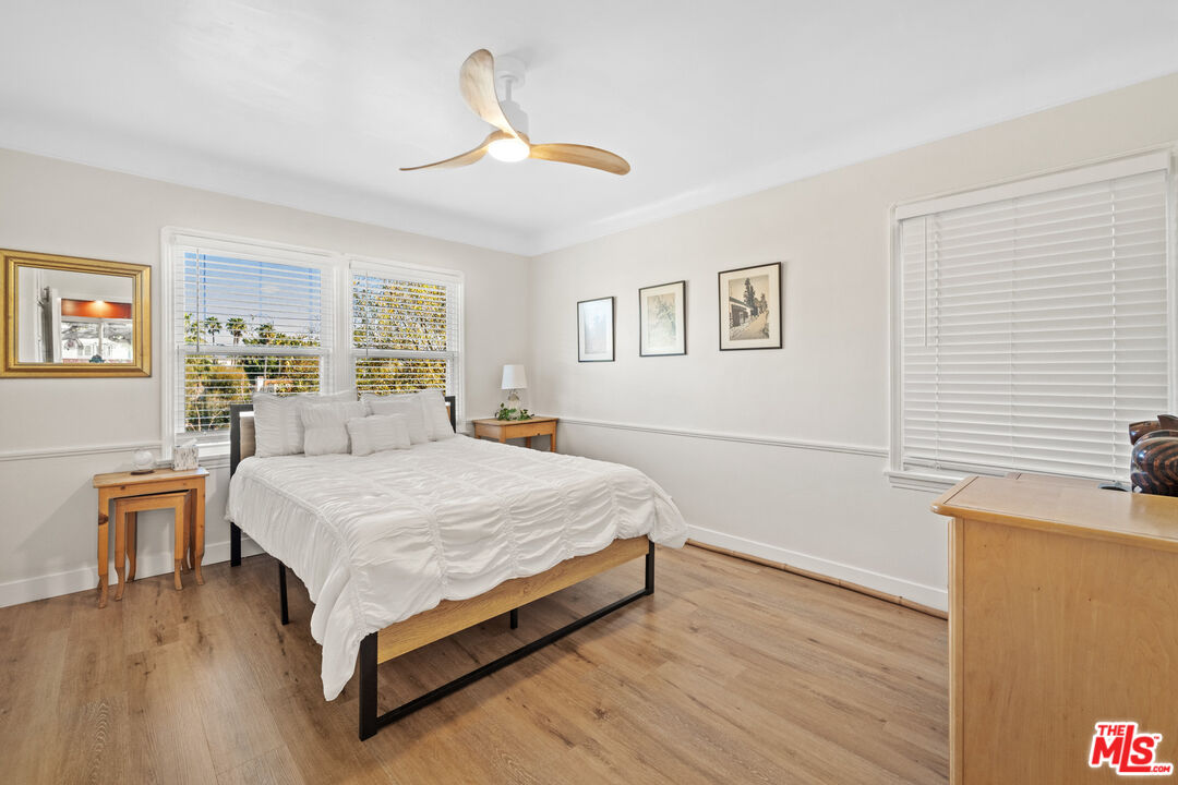 5008 Valley Ridge Avenue View Park, CA 90043 - Photo 18 of 28 a spacious bedroom with a bed and a chandelier