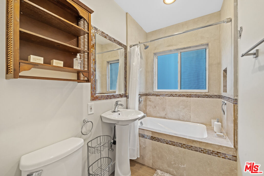 5008 Valley Ridge Avenue View Park, CA 90043 - Photo 19 of 28 a bathroom with a sink a toilet and a bathtub