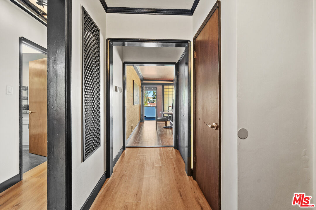 5008 Valley Ridge Avenue View Park, CA 90043 - Photo 6 of 28 a view of a hallway with wooden floor and a bathroom