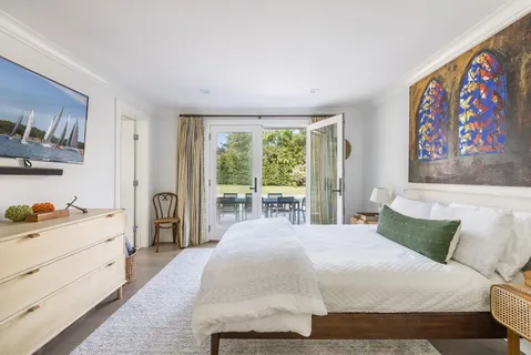 a bedroom with a bed and a painting on the wall