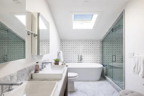 a bathroom with a tub sink and mirror