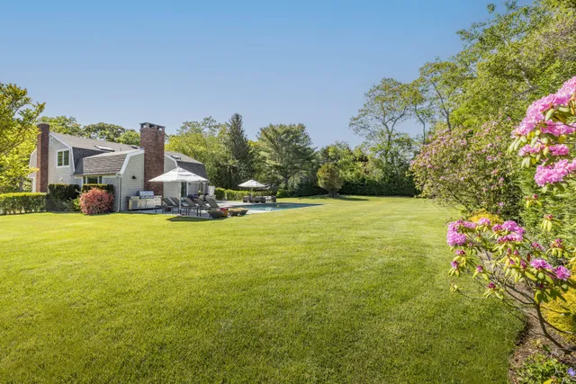 a view of a house with a big yard and potted plants