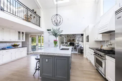 a kitchen with stainless steel appliances granite countertop a stove a sink and a refrigerator