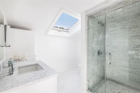 a bathroom with a granite countertop sink a shower and a mirror