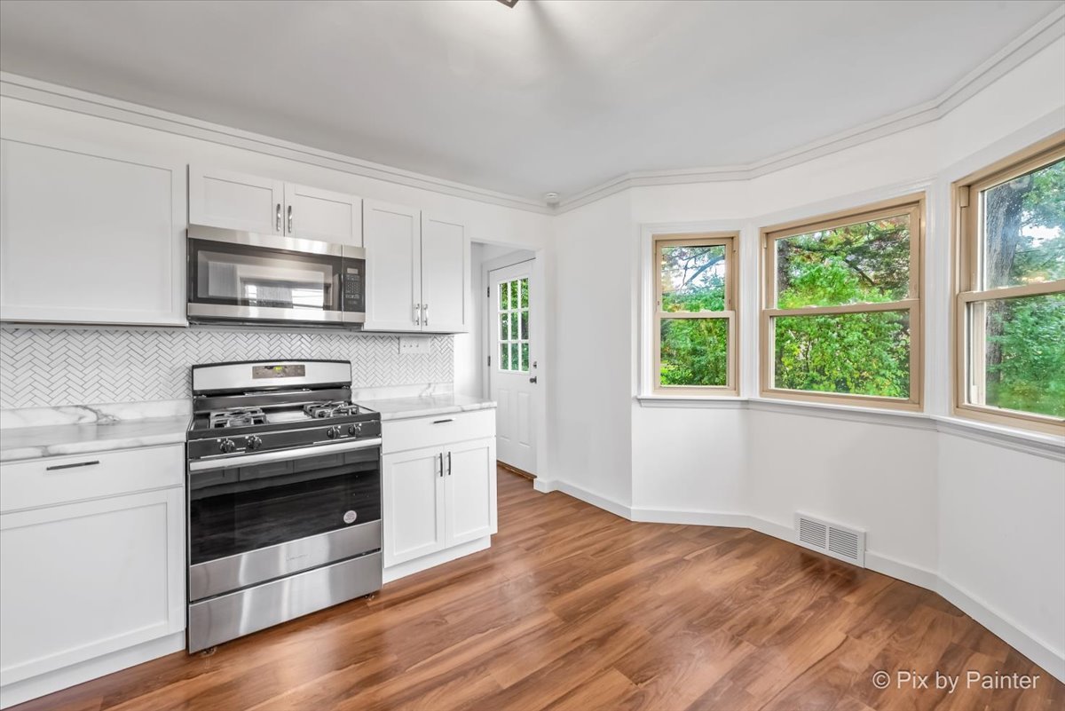 3019 Lincoln Road McHenry, IL 60051 - Photo 8 of 28 a kitchen with granite countertop a stove a sink and a microwave