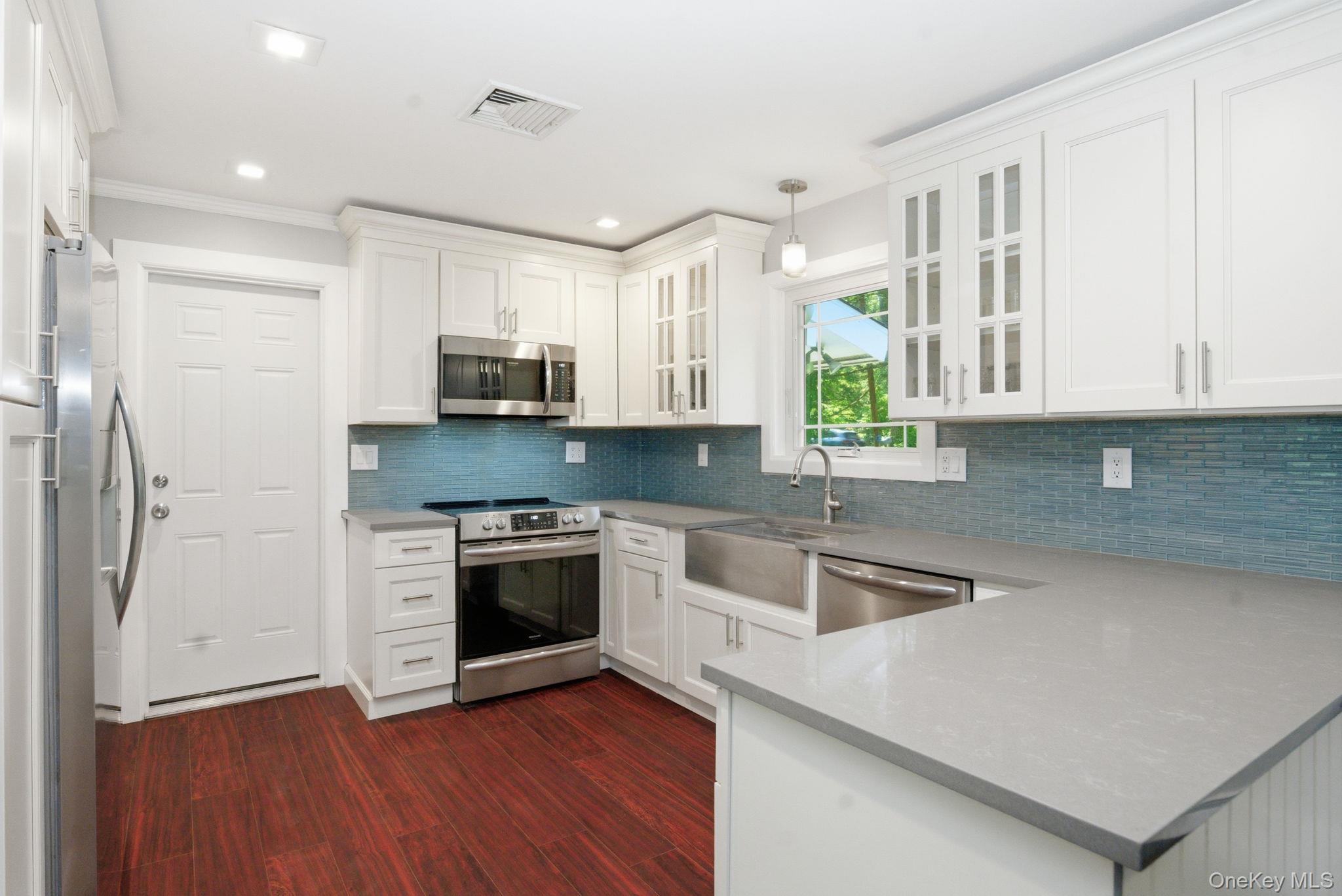 35 Deans Bridge Road Somers, NY 10589 - Photo 5 of 49 Stainless steel appliances and a deep farmhouse sink make this updated kitchen as functional as it is beautiful.