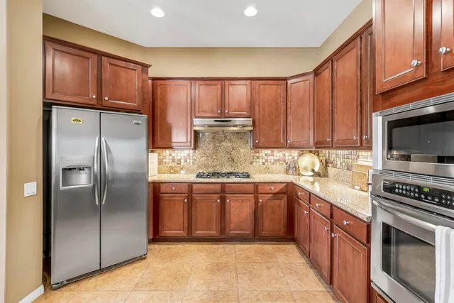 a kitchen with stainless steel appliances granite countertop a refrigerator oven a sink and dishwasher
