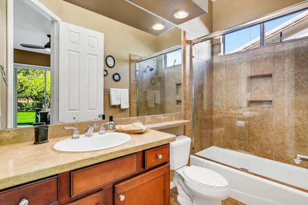 a bathroom with a sink a toilet a mirror and shower