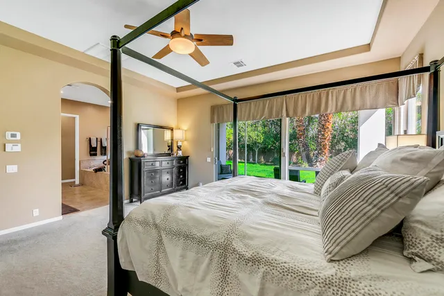 a bed sitting in a bedroom next to a large window