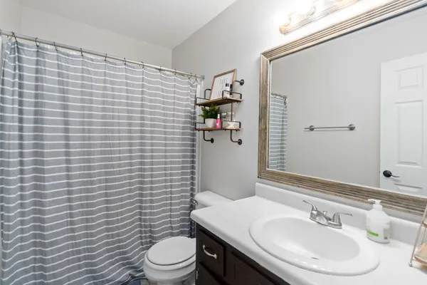 a bathroom with a sink a toilet and shower curtain