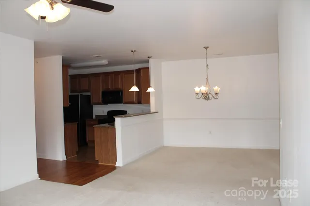 a view of empty room with chandelier fan and window