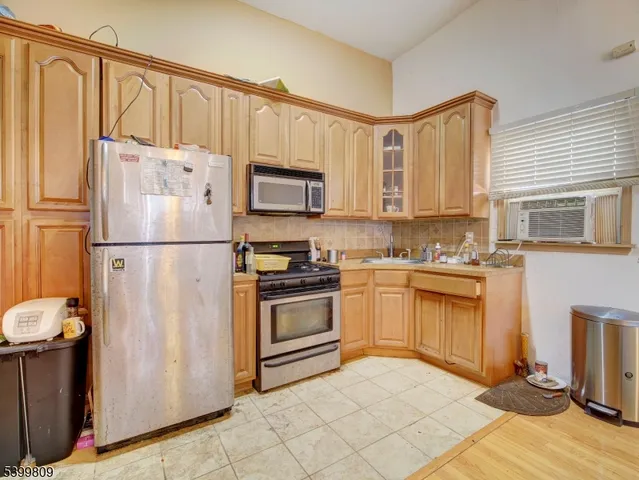 a kitchen with stainless steel appliances kitchen island granite countertop a table chairs and a refrigerator