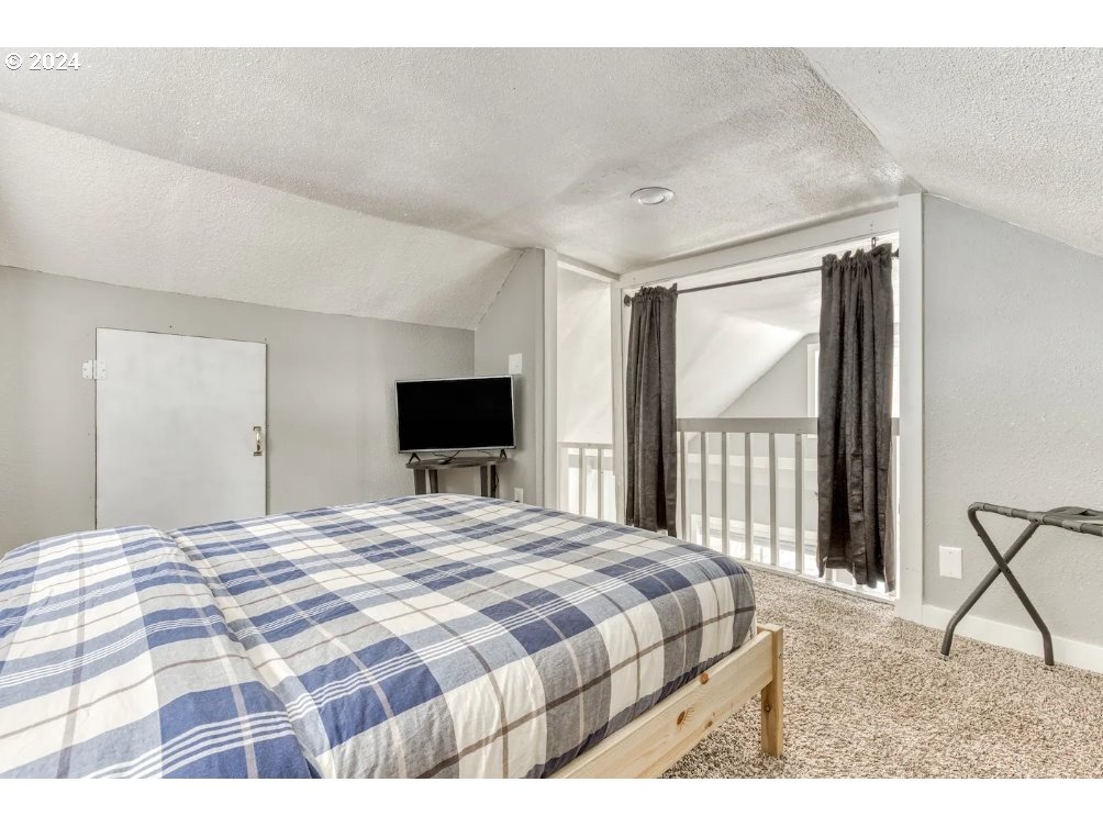 23795 East Lolo Pass Road Rhododendron, OR 97049 - Photo 15 of 19 a bedroom with a balcony a bed and a flat screen tv
