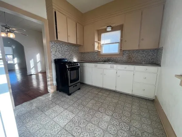 a kitchen with granite countertop a stove a sink and a granite counter tops