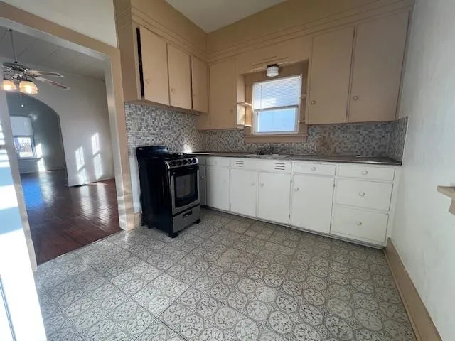 a kitchen with granite countertop a stove a sink and a granite counter tops