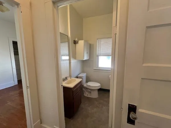 a bathroom with a toilet sink and mirror