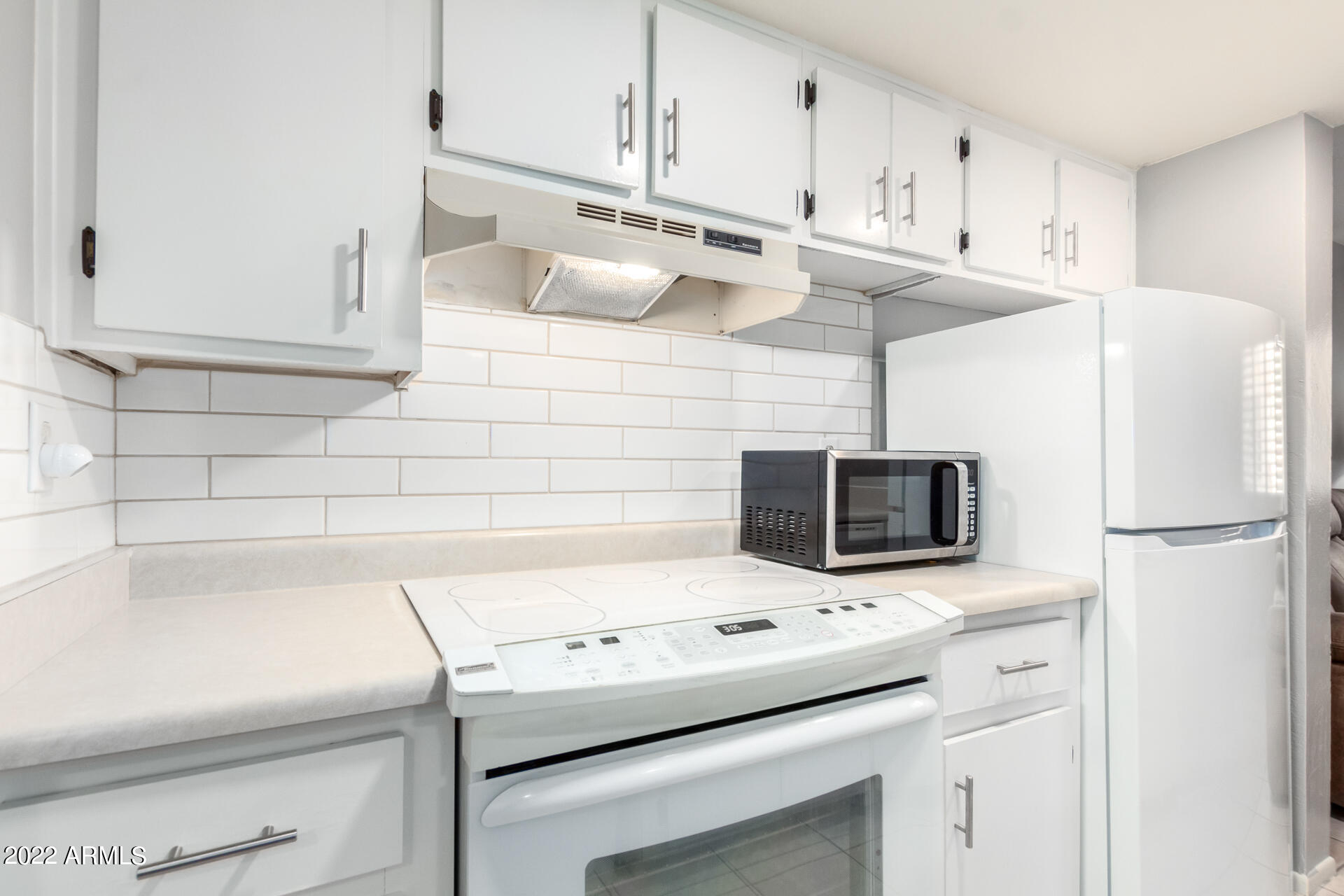 12123 West Bell Road, Unit 159 Surprise, AZ 85378 - Photo 2 of 21 a kitchen with stainless steel appliances a microwave a sink and a refrigerator